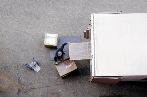 Movers carrying office equipment through a North London building